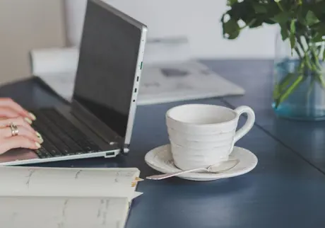 Närbild på laptop och kaffekopp