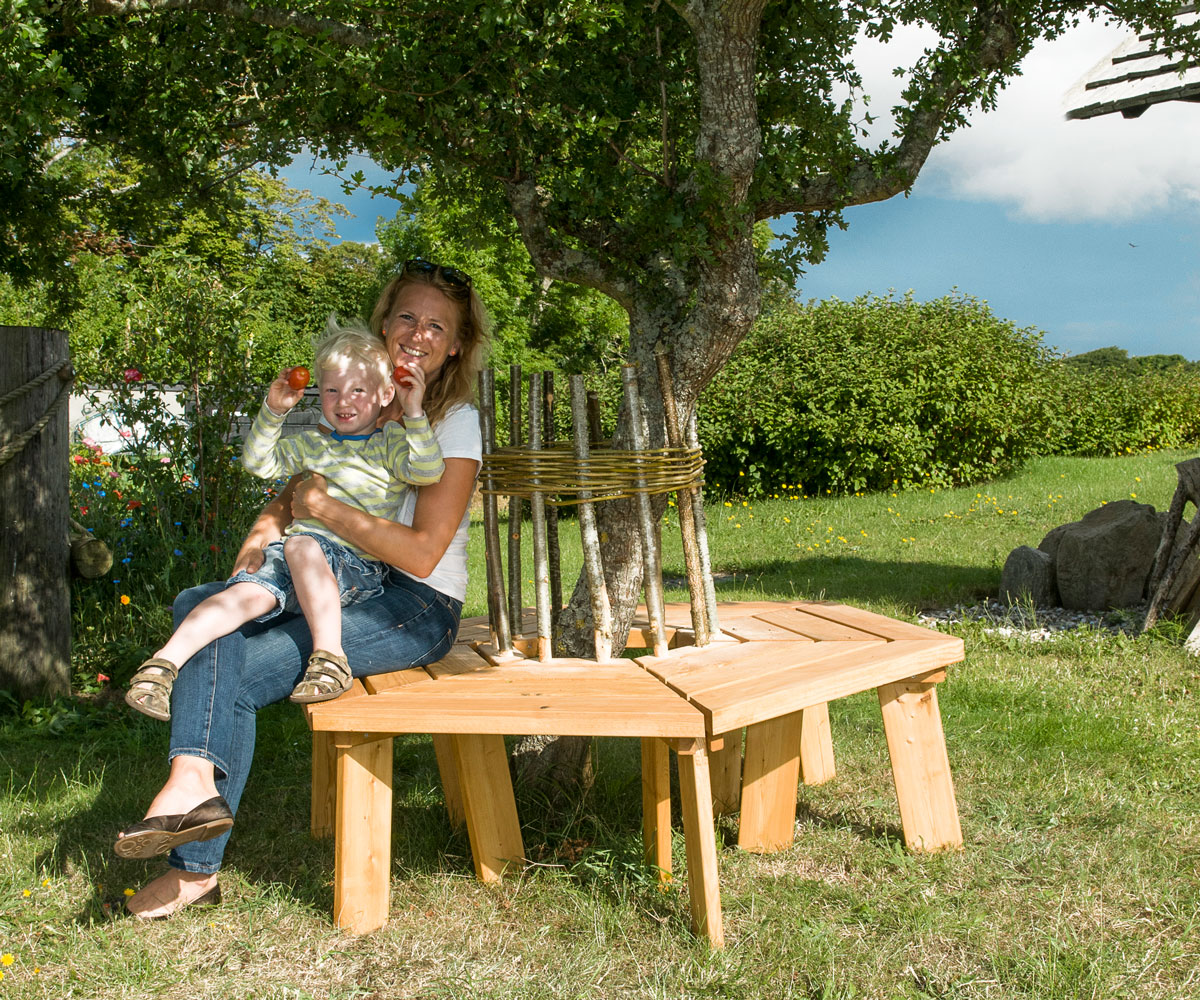 Mor och son sitter på hemgjord trädgårdsbänk