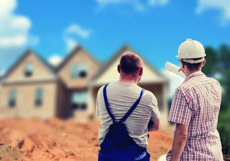 Byggnadsingenjör och hantverkare tittar på hus