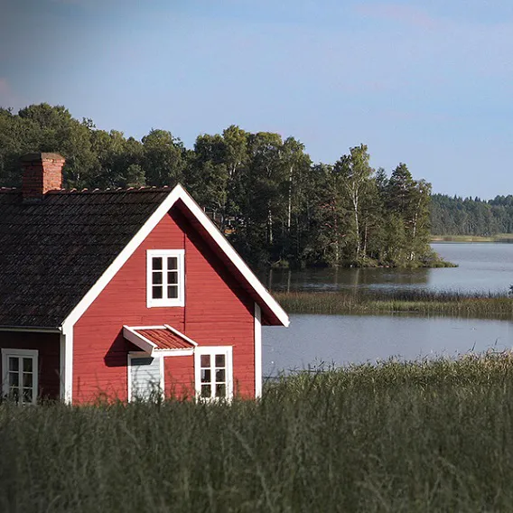 Rött fritidshusvid vattnet