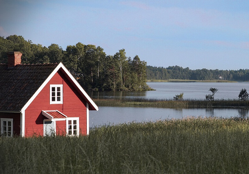 Rött fritidshusvid vattnet