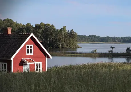 Rött fritidshusvid vattnet