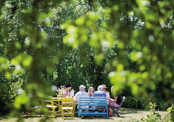 Familj fikar i lummig trädgård