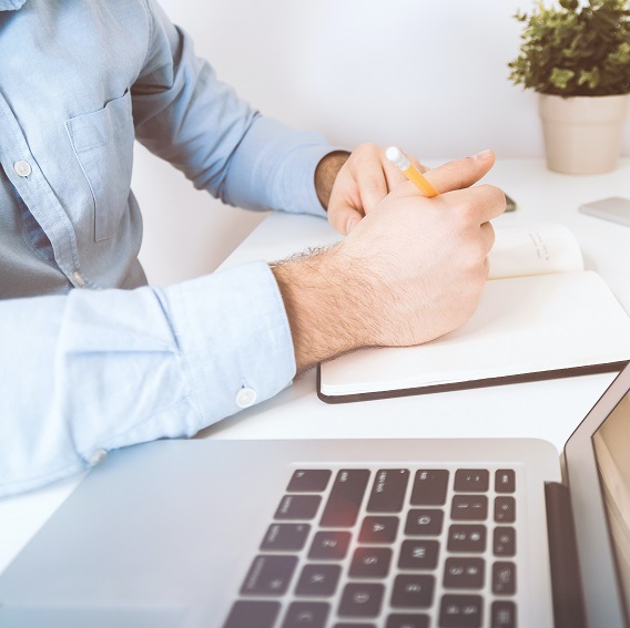 Man antecknar vid laptop