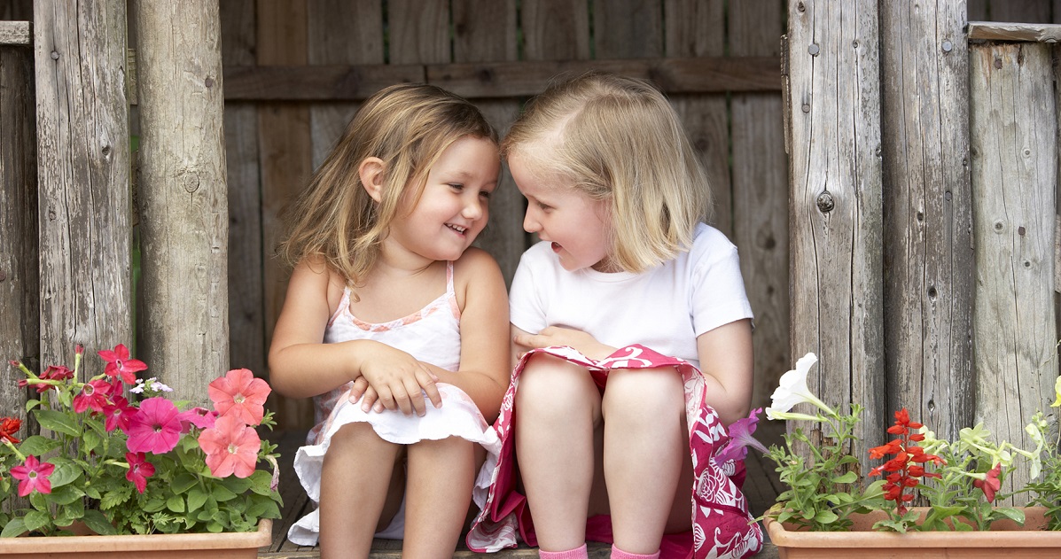 Glada flickor sitter på trapp