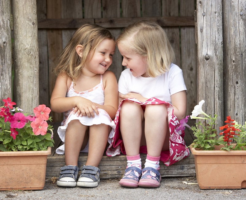 Barn sitter på trappa och skrattar
