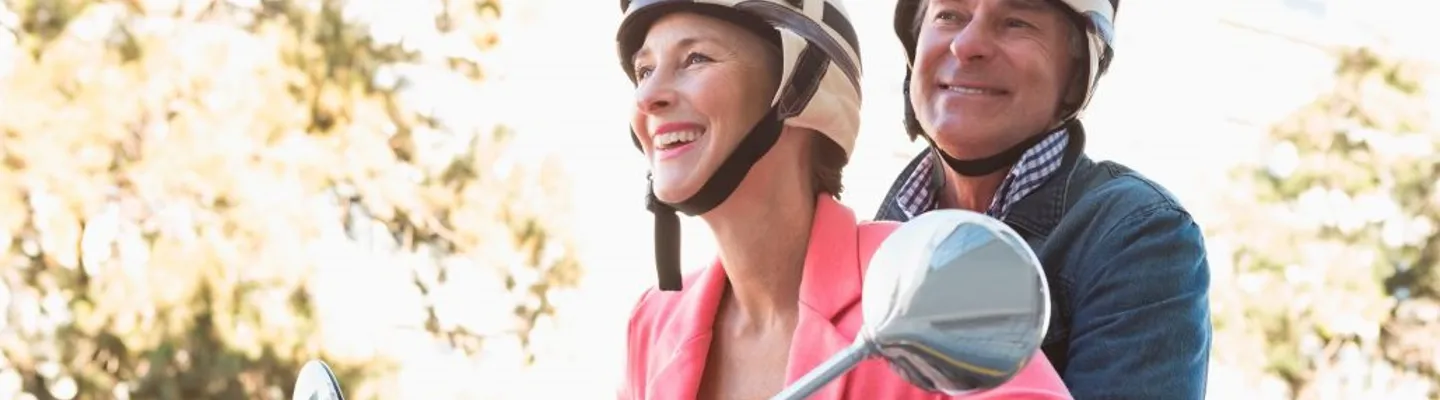 Äldre par glada på moped