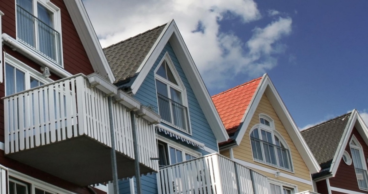 Flerfärgade hus med balkonger mot blå himmel