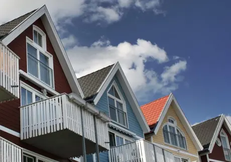 Flerfärgade hus med balkonger mot blå himmel