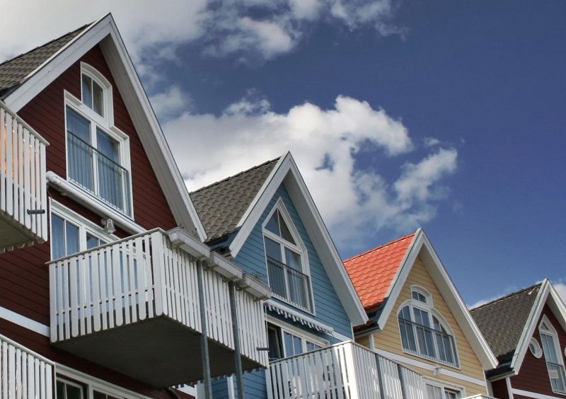 Flerfärgade hus med balkonger mot blå himmel
