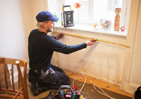Hantverkare mäter vid fönster