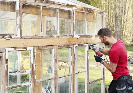 Hantverkare borrar på glashus
