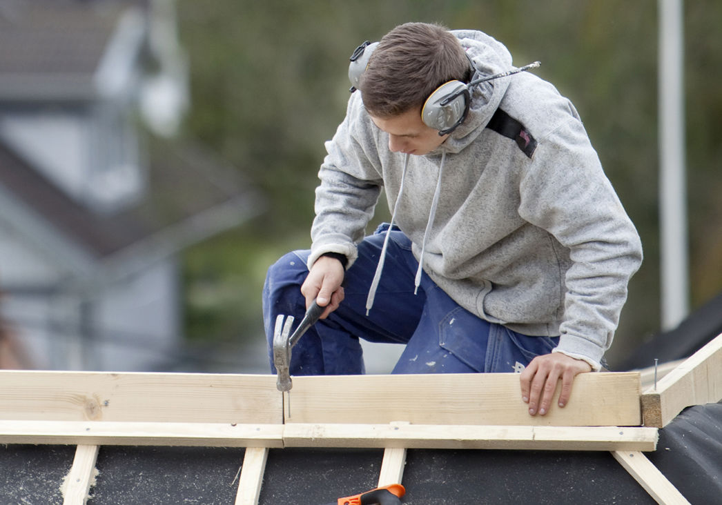 Hantverkare på tak spikar planka