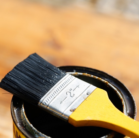 Gul pensel på burk och laserad planka