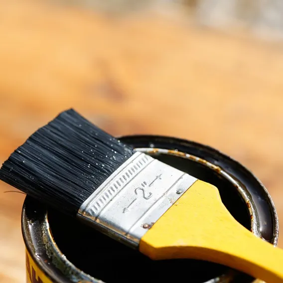 Gul pensel på burk och laserad planka