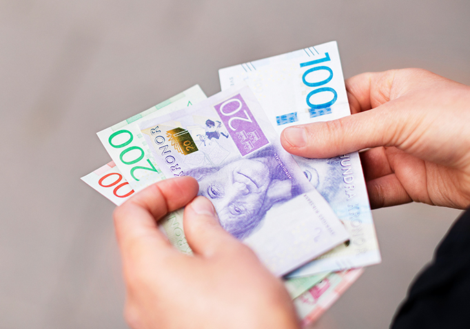 Händer håller i sedlar