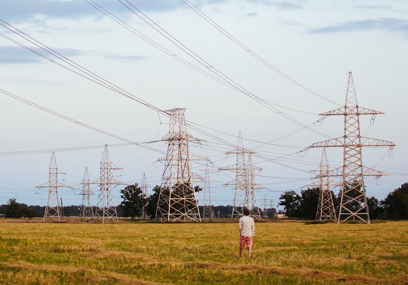 Man står på fält med elmaster