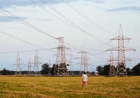 Man står på fält med elmaster