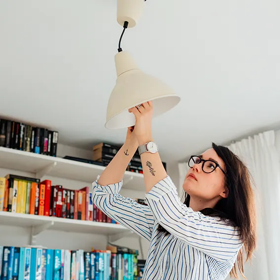 Tjej plockar ut glödlampa