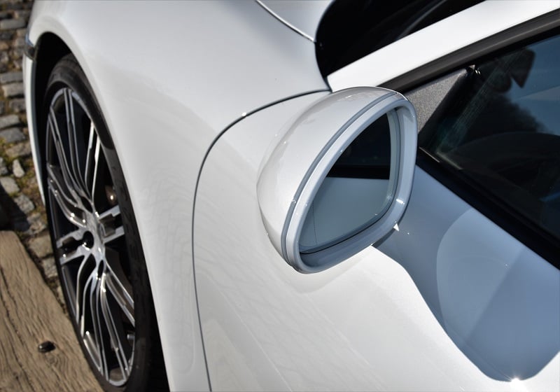 Vit bil med fälg och sidospegel