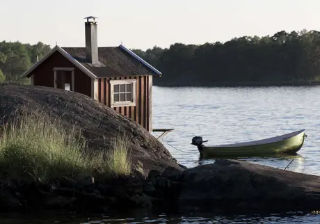 Båthus i skärgården med motorbåt fastsurrad