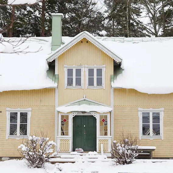 Gammalt gult hus i vinterskrud