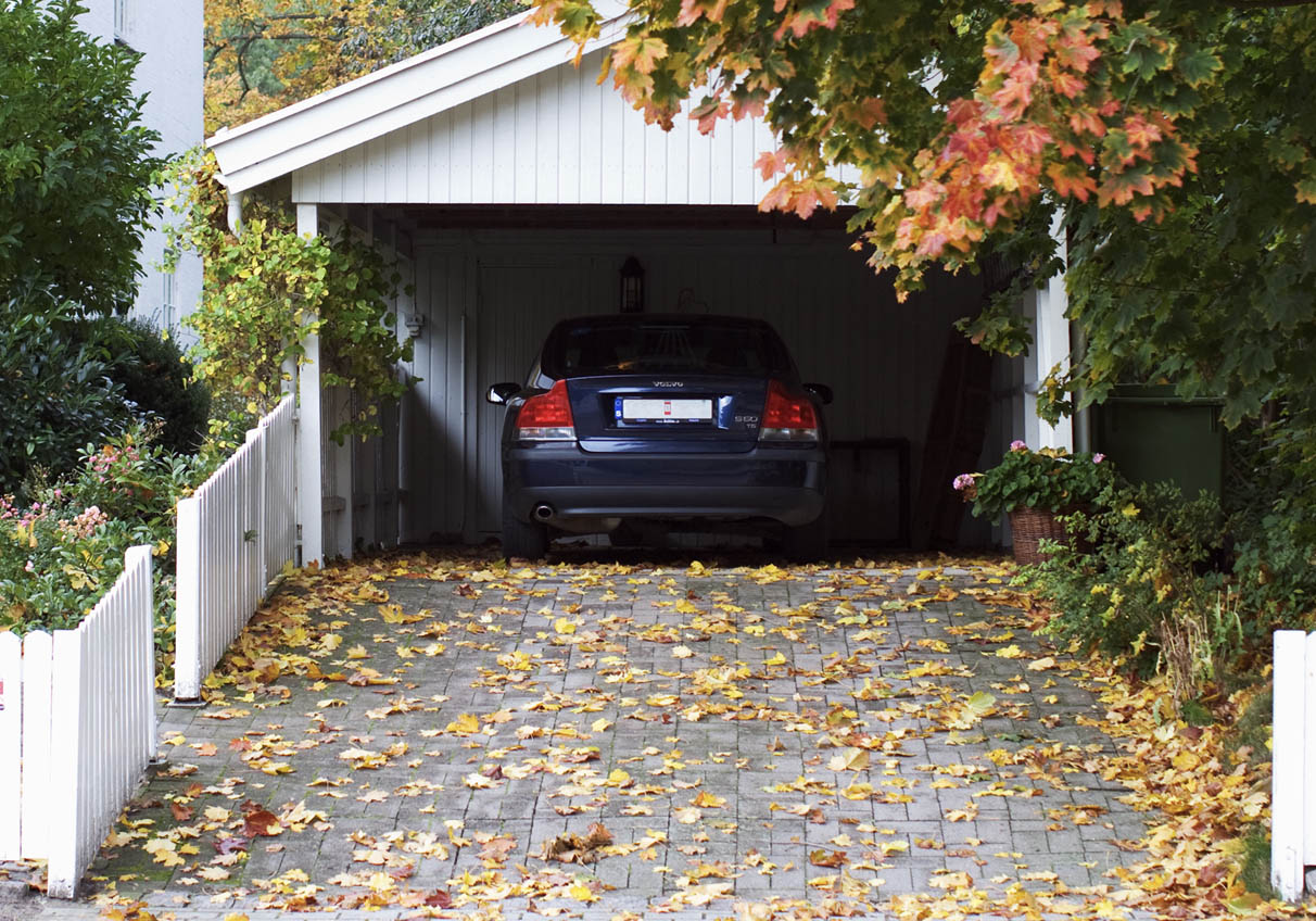 Bil i carport med en höstig uppfart