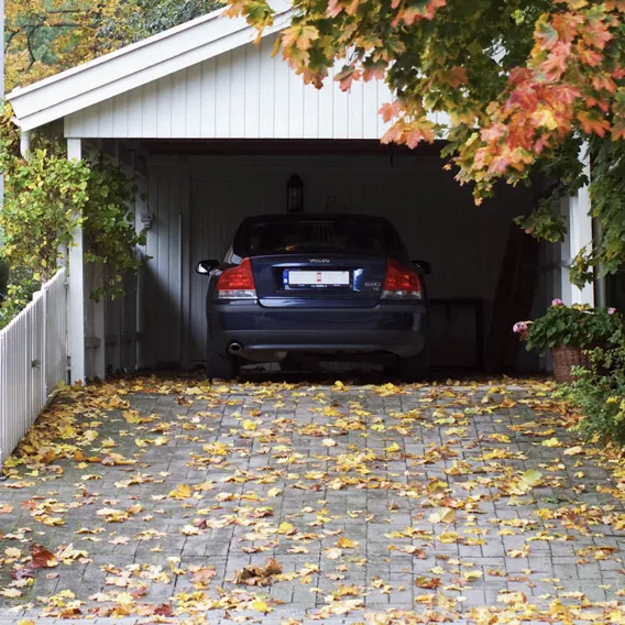 Bil i carport med en höstig uppfart