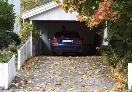 Bil i carport med en höstig uppfart