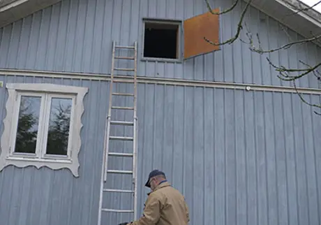 Blått hus med stege upp till öppen kallvind