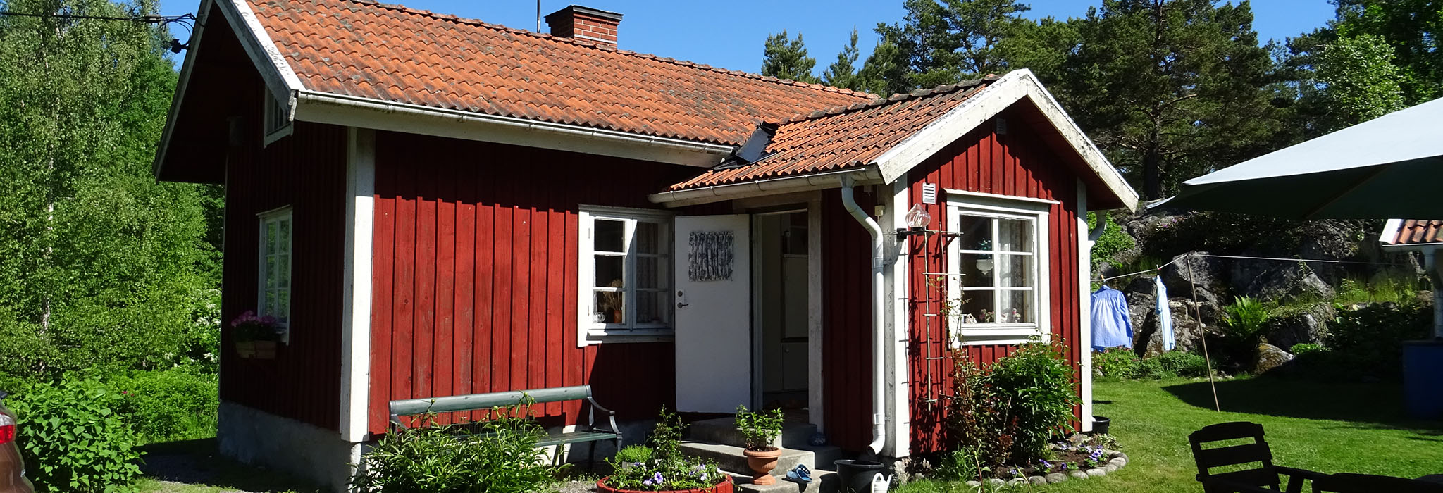 Idyllisk röd stuga med trädgård