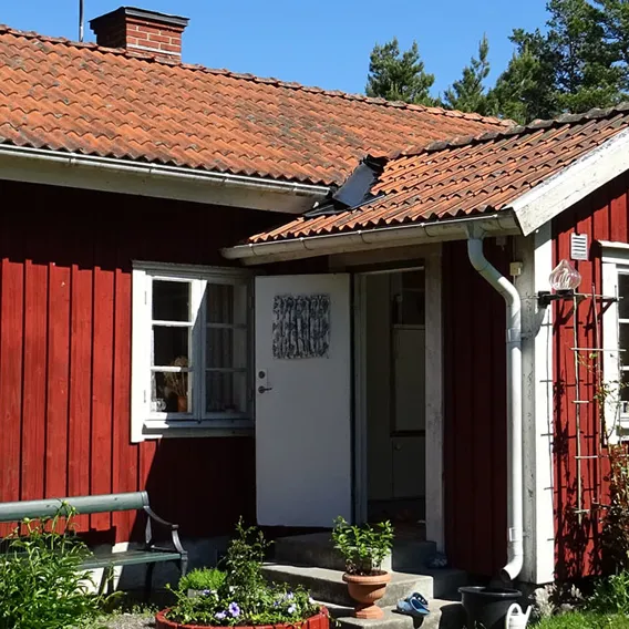 Idyllisk röd stuga med trädgård