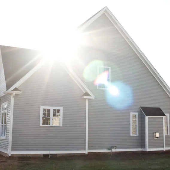Stort modernt hus med solstrålar på taket