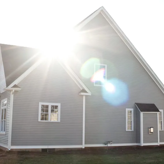 Stort modernt hus med solstrålar på taket