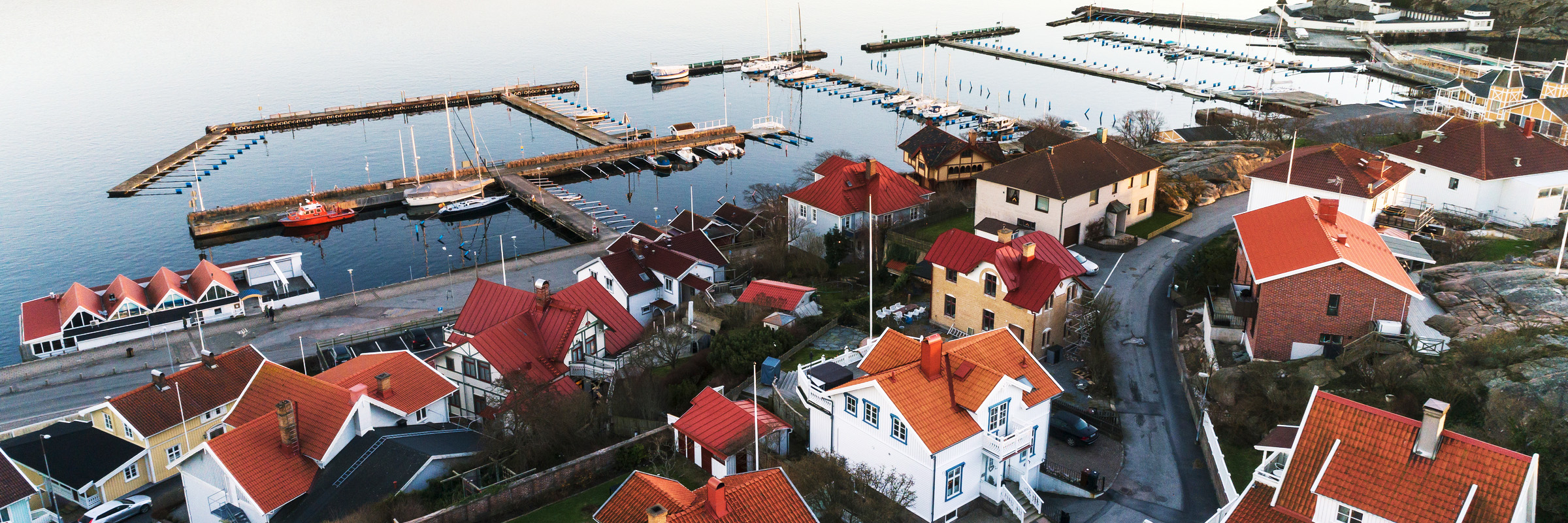 Villaområde vid havet med hamn i bakgrunden