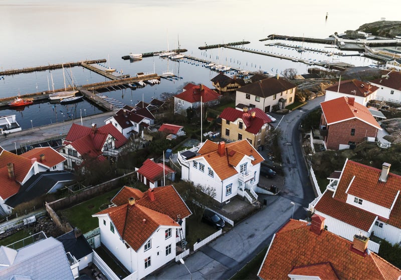 Villaområde vid havet med hamn i bakgrunden