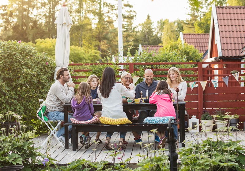Familj fikar på uteplats i solen