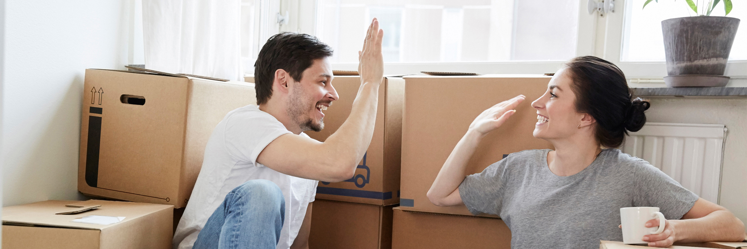 Par sitter bland flyttkartonger