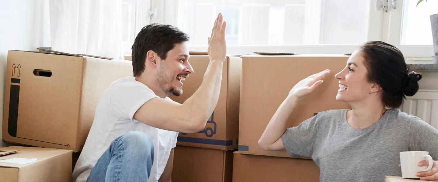 Par sitter bland flyttkartonger