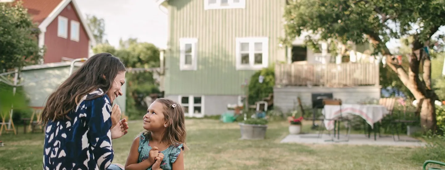 Mor och dotter på tomt utanför hus