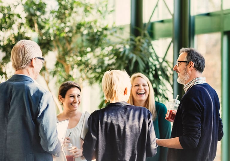 Människor pratar och skrattar i folksamling