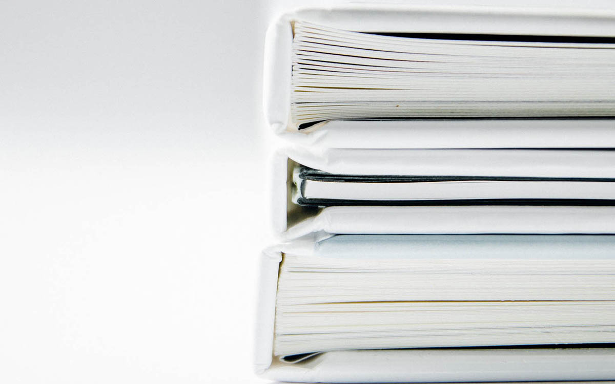 Vita pärmar med papper staplade på hög