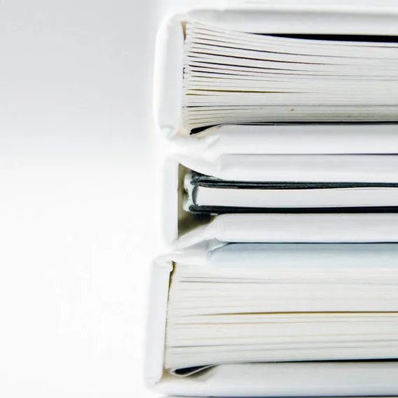 Vita pärmar med papper staplade på hög