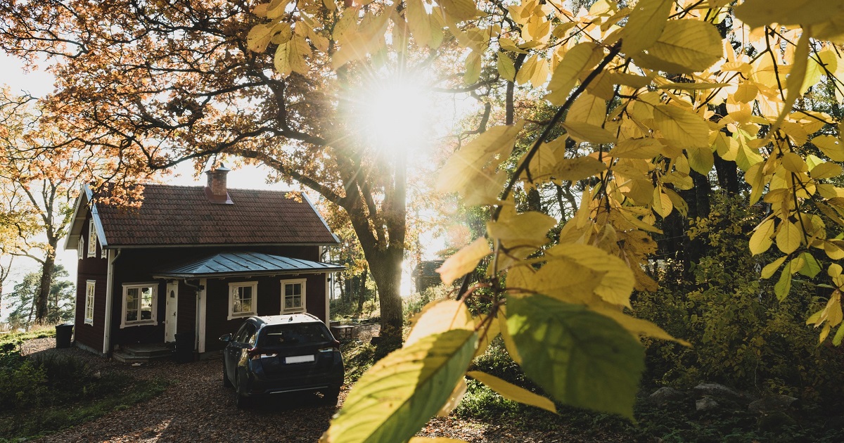 Fritidshus i höstmiljö med bil parkerad
