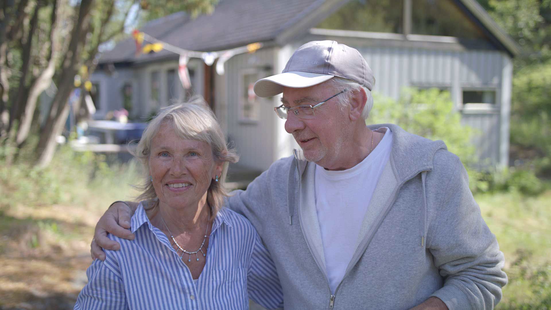 Glada pensionärer håller om varandra