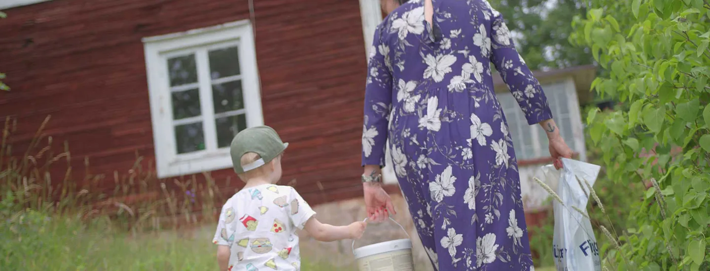 Mamma och son bär färgburk tillsammans