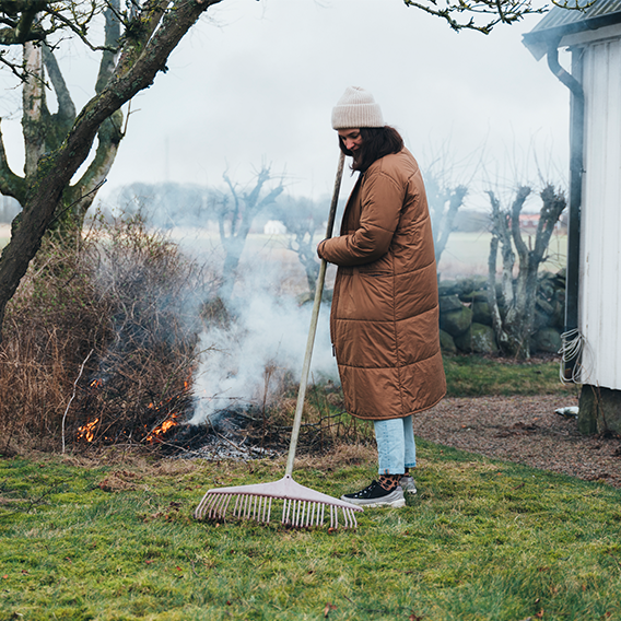 Kvinna eldar i trädgård
