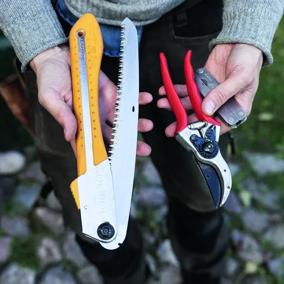 Man håller i trädgårdsredskap