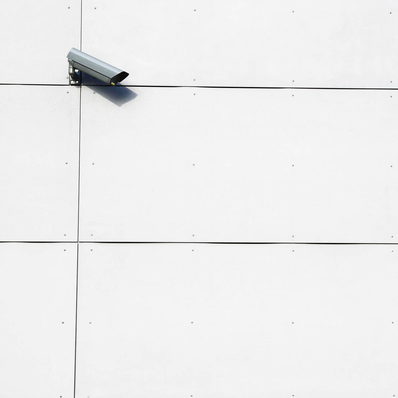 Övervakningskamera på vit vägg
