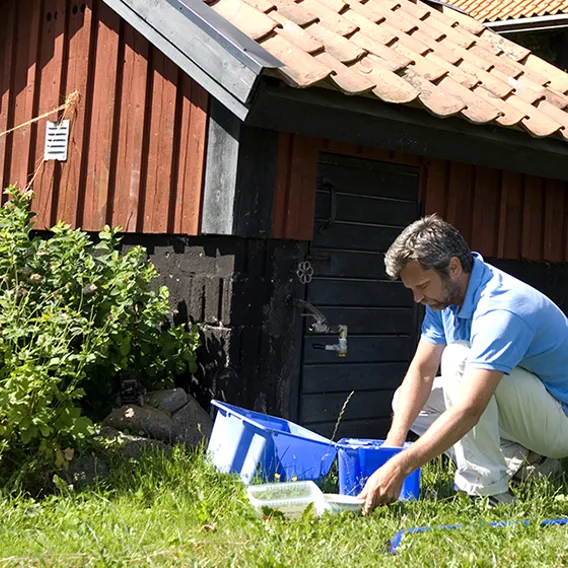 Man diskar i baljor utanför hus